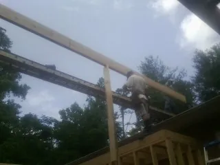 Carpenter setting a ridge beam over a new addition frame — Ice Dam Removal by Roofing Brothers in Berlin